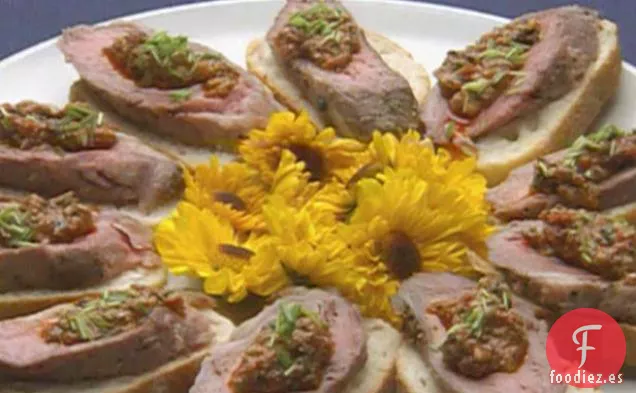 Lomo de Cordero Asado con Costra de Ajo y Pimienta con Hachís de Tomate servido en Crostini