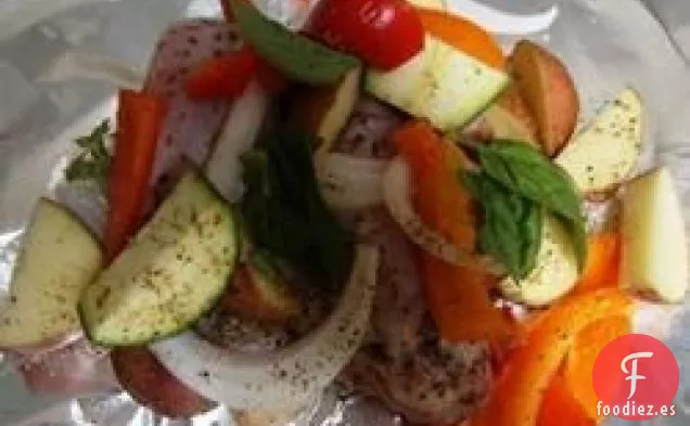 Paquetes de pollo a la parrilla y papas en papel de aluminio