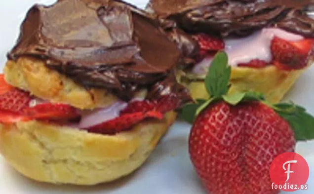 Bollos de crema rellenos de fresa y glaseados con chocolate